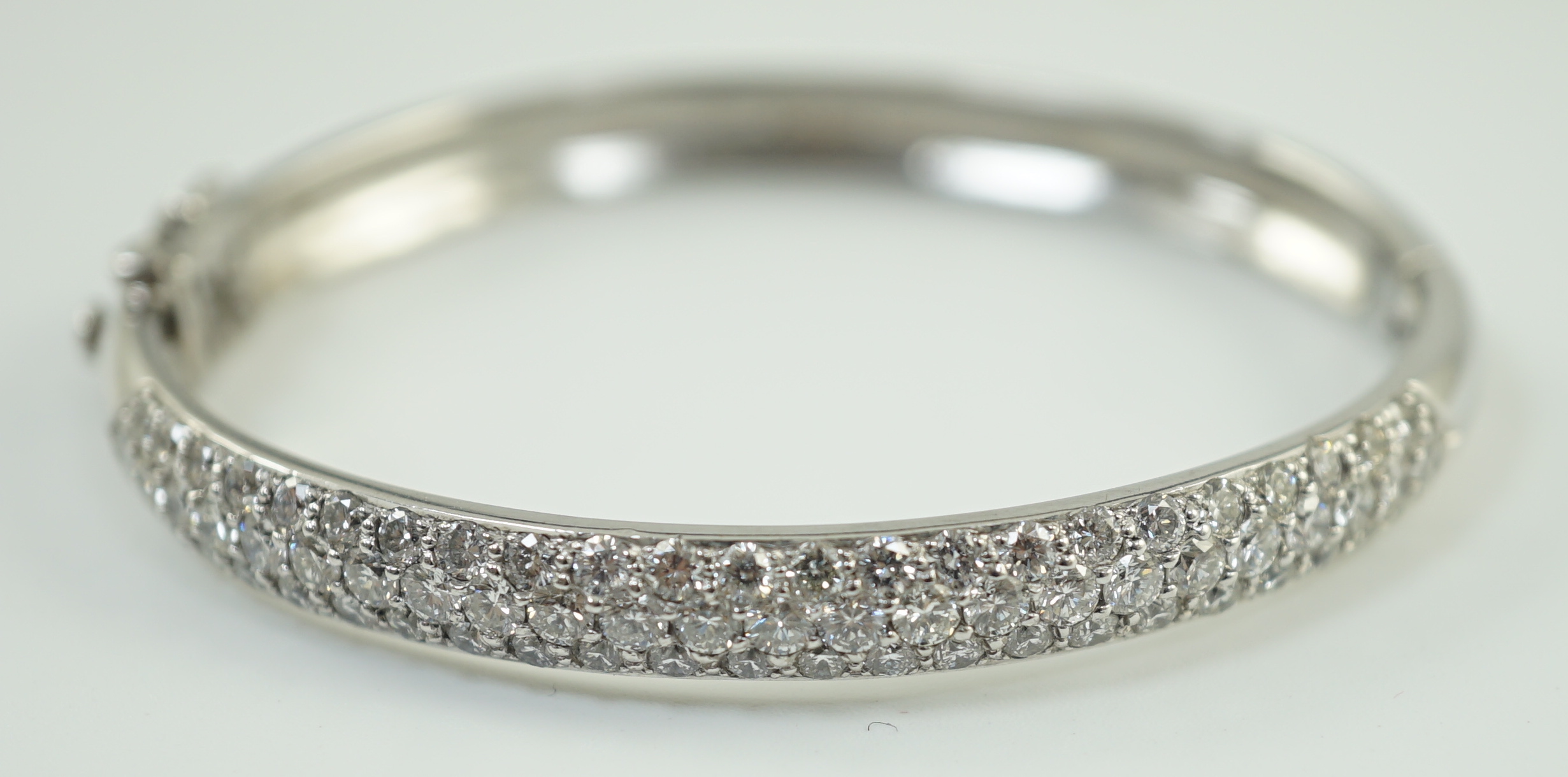 A modern 18ct white gold and pave set diamond hinged bangle